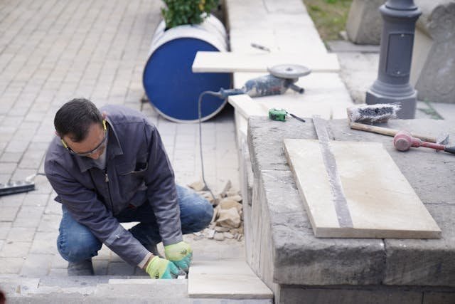 Tiles mason installing floor and wall tiles at construction site in Saudi Arabia